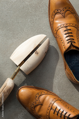 Overhead view of a pair of tan brown leather mens formal shoes on concrete photo