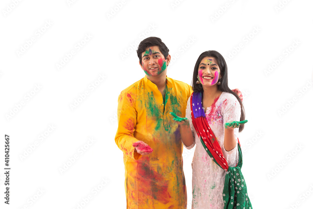 A YOUNG WOMAN AND MAN HAPPILY STANDING IN FRONT OF CAMERA WITH COLOUR ALL OVER	