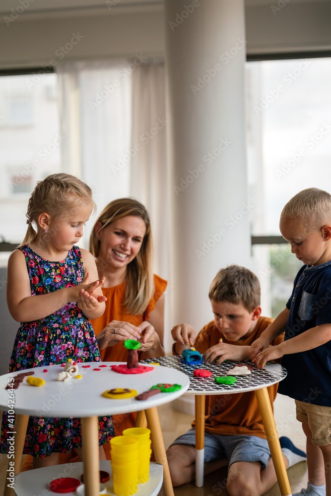 Family, children, education, happiness concept. Mother teaches preschooler kids to do craft items. Family, children, education, happiness concept. Mother teaches preschooler kids to do craft items.