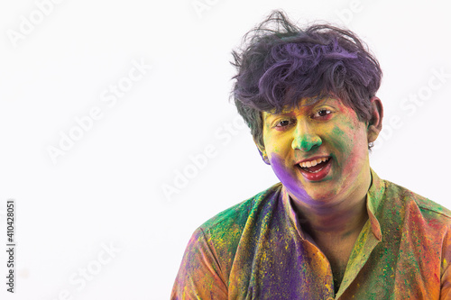 PORTRAIT OF A YOUNG MAN WITH COLOURS ALL OVER LOOKING AT CAMERA AND SMILING	