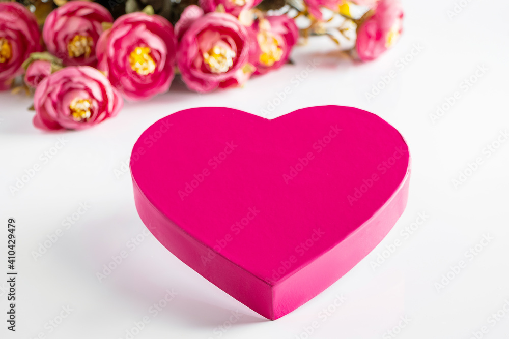 Obraz premium Pink heart for valentines day on a background of flowers.