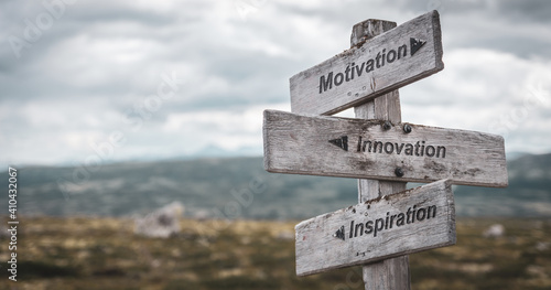motivation innovation inspiration text engraved on wooden signpost outdoors in nature. Panorama format. © Jon Anders Wiken