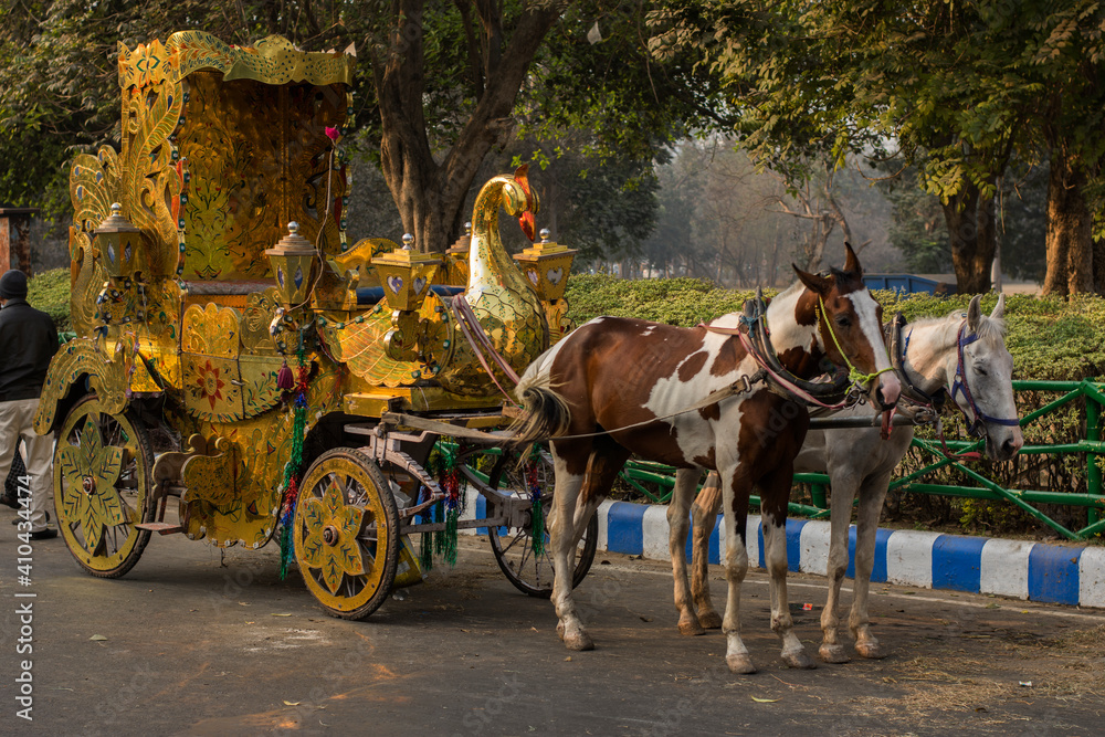 Kolkata, India, 25th December, 2020. Image of a golden chariot with two horses on the road. Kolkata, India, 25th December, 2020. Image of a golden chariot with two horses on the road.