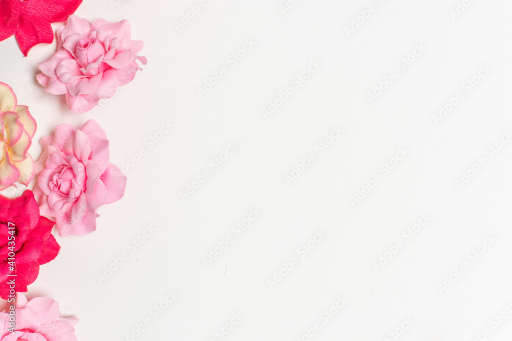 Frame made of rose flowers on white background. Top view with copy space.