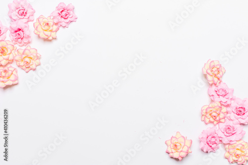 Frame made of rose flowers on white background. Top view with copy space.