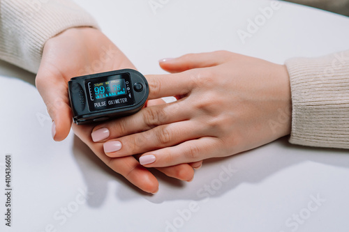 Measuring amount of oxygen in blood with pulse oximeter. Saturation and pulse checking at home, fast diagnostics of Covid-19. Close-up monitor view.