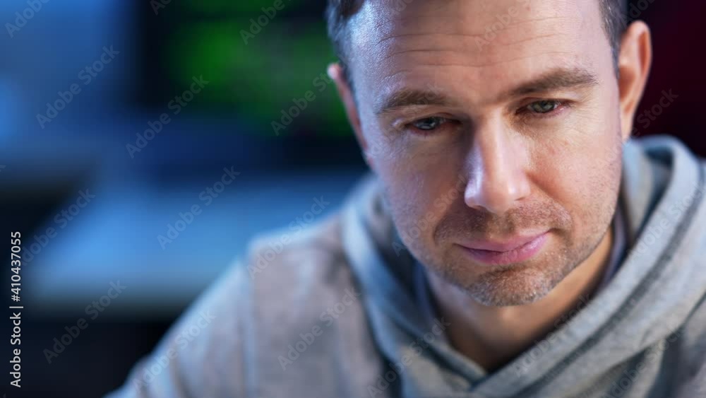 Close-up face of confident concentrated Caucasian programmer coder typing on keyboard coding application or hacking website. Portrait of focused young man indoors. Hacking and lifestyle. Close-up face of confident concentrated Caucasian programmer coder typing on keyboard coding application or hacking website. Portrait of focused young man indoors. Hacking and lifestyle.