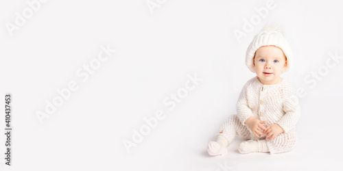 baby crawls in a warm suit and hat on a white isolated background, space for text, banner