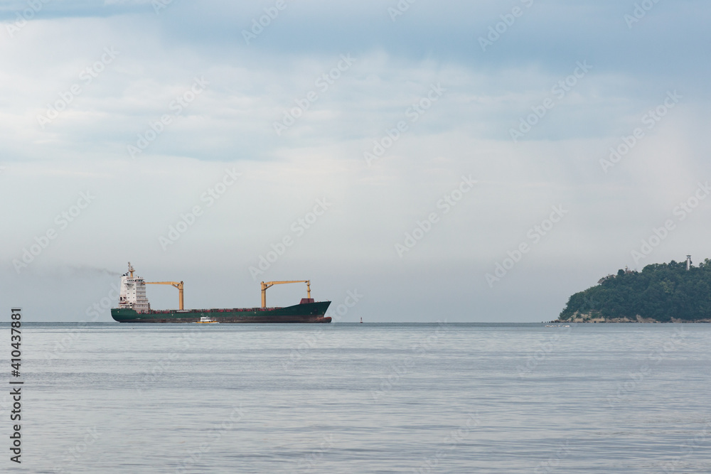 container ship being maneuvered by a tugboat