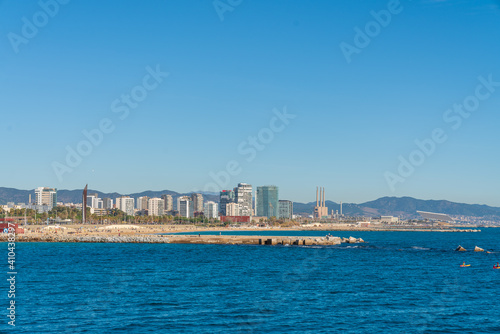 BARCELONA, SPAIN, FEBRUARY 3, 2021: Barcelona coast a sunny winter day. During the covid-19 pandemic. View from inside the water. In the background we can see the new modernist buildings on the coast.