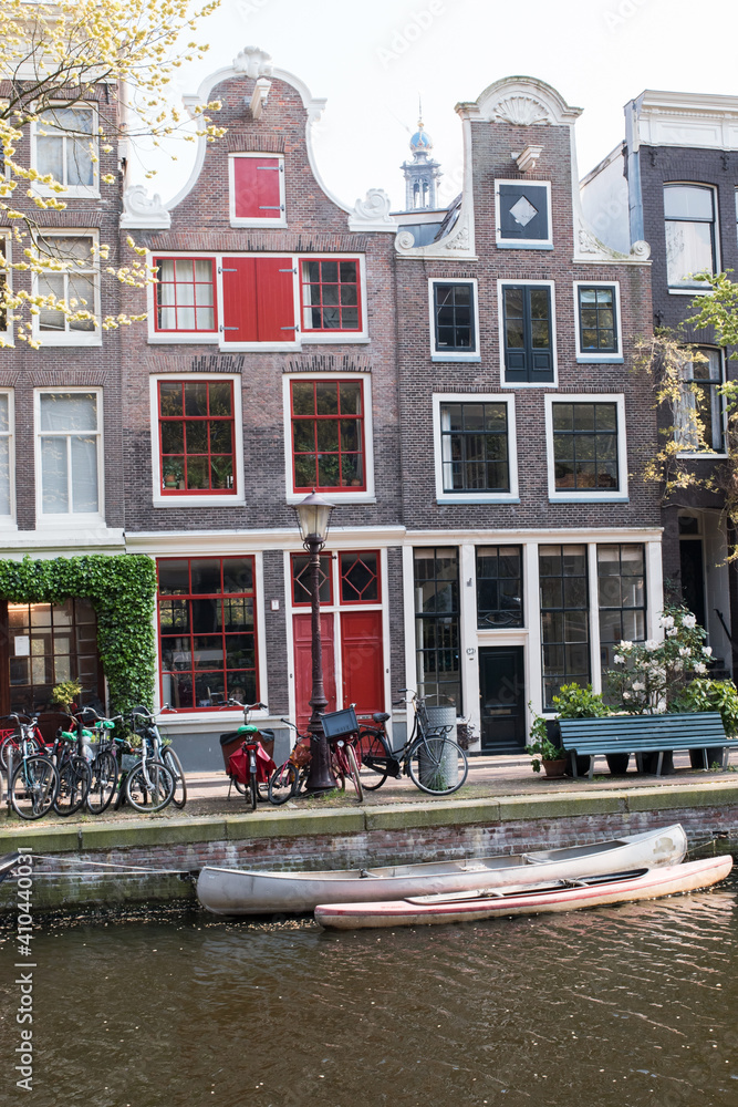 Obraz premium Homes along a canal in Amsterdam, with canoes at the ready.