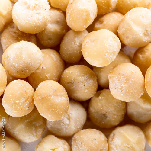 Background of big raw peeled macadamia nuts, situated arbitrarily.