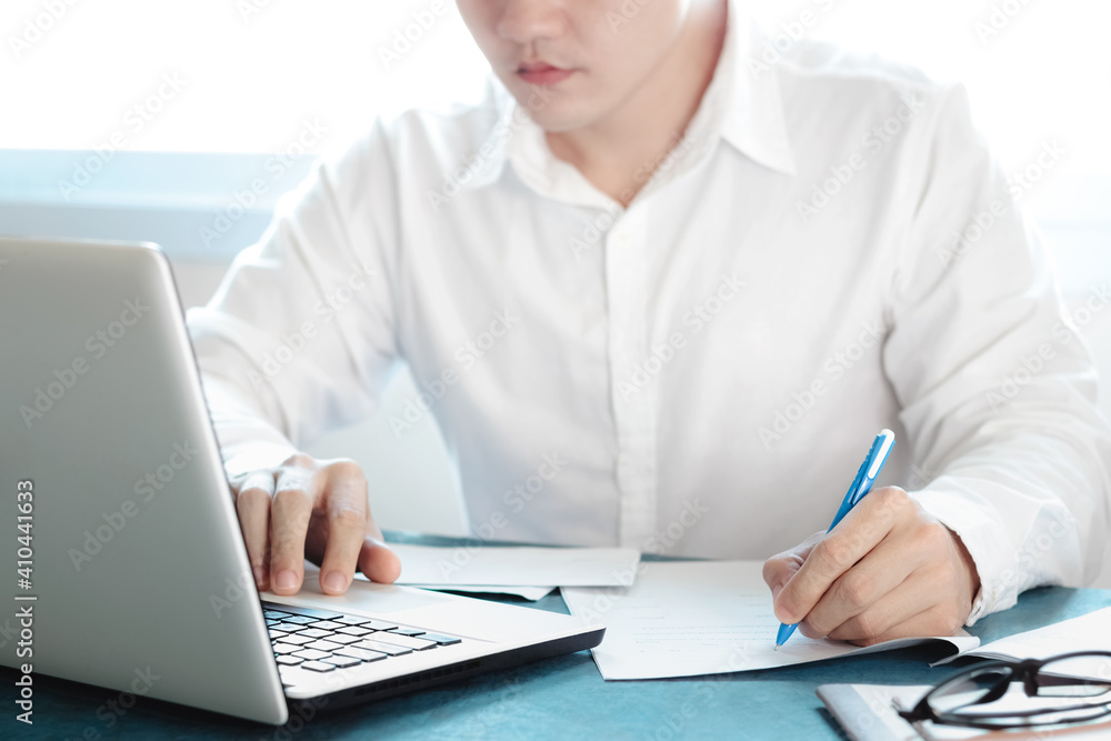 Asian men working at their desks with notebooks taking notes Accepting orders from online customers, online business and e-commerce, Online stores selling products. Asian men working at their desks with notebooks taking notes Accepting orders from online customers, online business and e-commerce, Online stores selling products.
