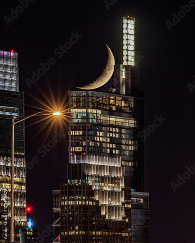 Crescent moon setting behind Comcast Technology Center in Philadelphia 