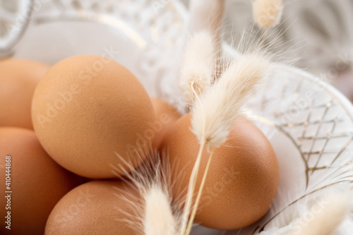 Congratulatory Easter background. Background with copy space. Selective focus. easter eggs  in a white basket on the table. 