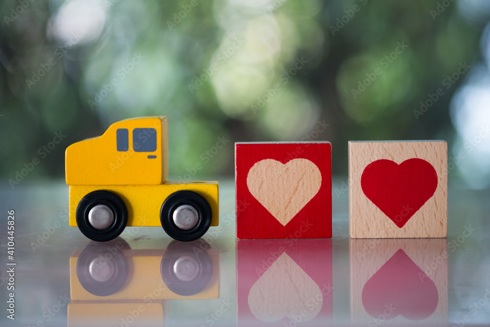 Wood heart follow yellow toy car for sending to couple. The concept of love. Wood heart follow yellow toy car for sending to couple. The concept of love.