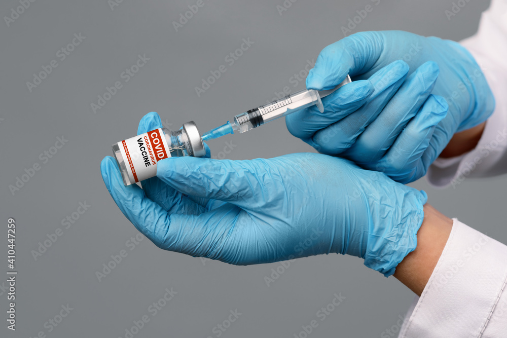 Hands In Blue Medical Gloves Filling Syringe With Covid-19 Vaccine From Vial Hands In Blue Medical Gloves Filling Syringe With Covid-19 Vaccine From Vial