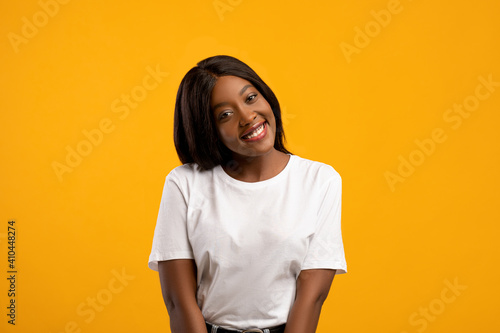 Cute black lady posing on yellow studio background