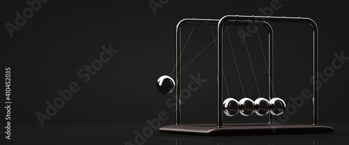 Newton's cradle in action. Copy space. Design element. Dark background.
