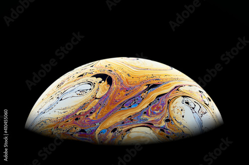 Half a soap bubble. Bright, beautiful patterns. Isolated on black background. Close-up.