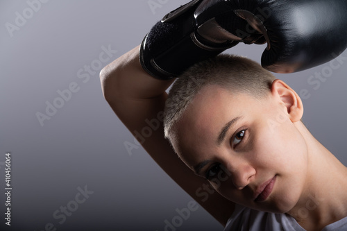 Young woman with short hair in boxing gloves on a white background