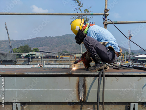 Foto Welder is gouging repair defect of welding with Air carbon arc gouging machine and dressed properly with personal protective equipment(PPE) for safety, at industrial factory