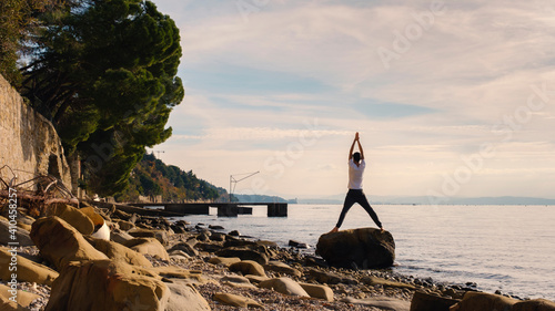 Attractive young man practicing yoga meditation and breathwork outdoors by the sea