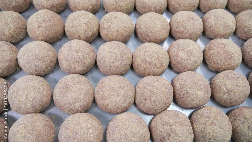 Close up shot of a metal plate tray of meat balls ready to be grilled roasted baked. Food production plant food industry. Close up shot of a metal plate tray of meat balls ready to be grilled roasted baked. Food production plant food industry.