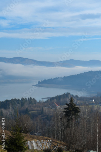 Landscape with blue lake and foggy mountains
