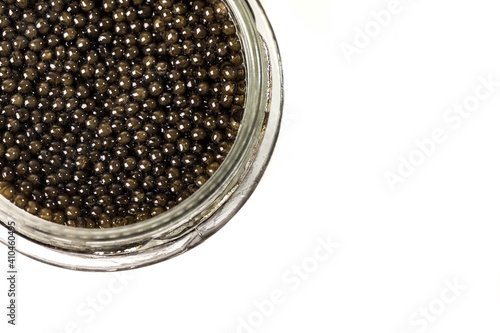 Premium black caviar in a glass jar on a white background. You don't see the whole bank. Product segment. Place for the inscription