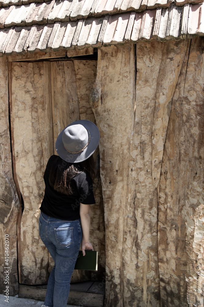 he woman opens the door of a wooden hous he woman opens the door of a wooden hous