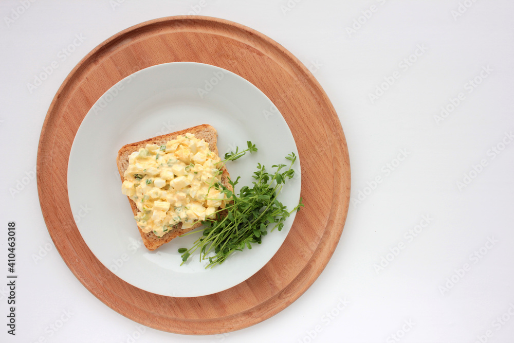 Egg salad sandwich with whole wheat toasted bread and microgreens on plate on white background. Healthy food concept
Egg salad sandwich with whole wheat toasted bread and microgreens on plate on white background. Healthy food concept