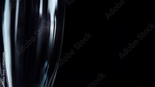Macro view of big high drinking glass against black background