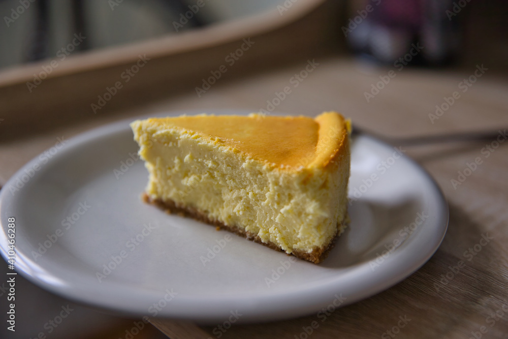 Slice of new york cheesecake on a white plate with fork. Depth of field Slice of new york cheesecake on a white plate with fork. Depth of field