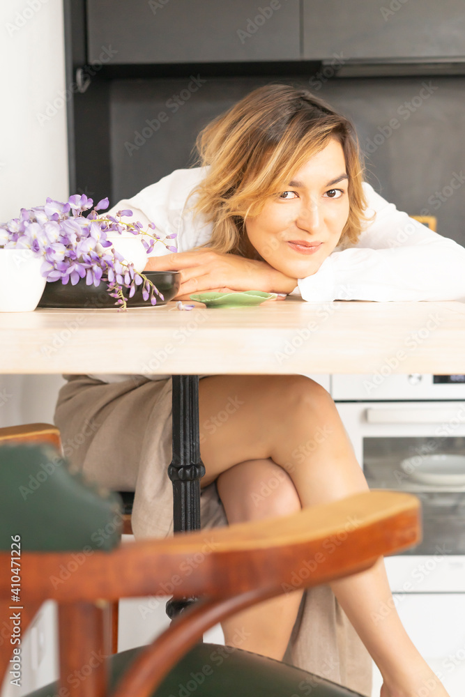 Cute girl sleeps at a table at home on the background of dirty dishes in the kitchen. Person is tired of cleaning the house and dreams Cute girl sleeps at a table at home on the background of dirty dishes in the kitchen. Person is tired of cleaning the house and dreams