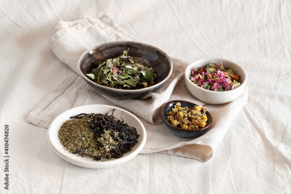 Different kinds of herbal tea in ceramic bowl top view. Homeopathy and herbal alternative medicine concept Different kinds of herbal tea in ceramic bowl top view. Homeopathy and herbal alternative medicine concept
