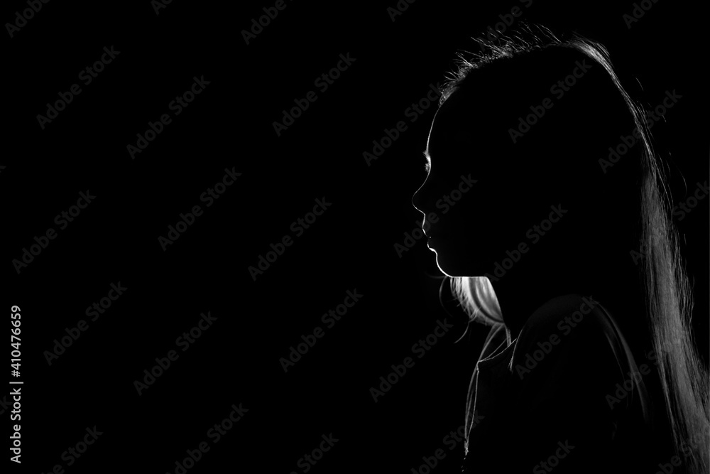 Silhouette of a young teenage girl on a black background