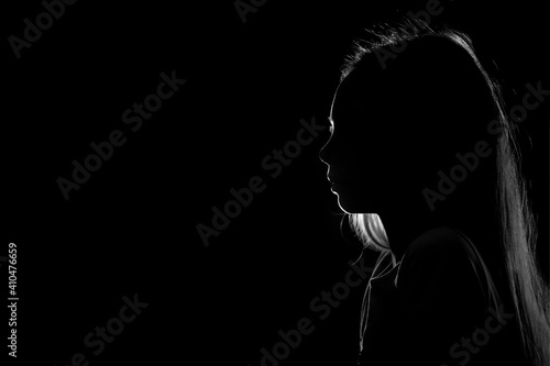 Silhouette of a young teenage girl on a black background