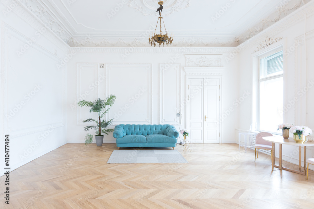 chic spacious light room in an old mansion in the classical style of the 19th century with a high ceiling decorated with stucco on white walls