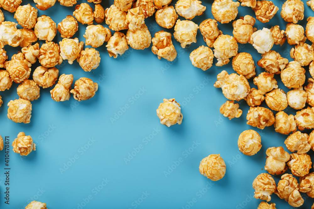 Caramel popcorn by a ripple on a blue background, in the form of a frame.