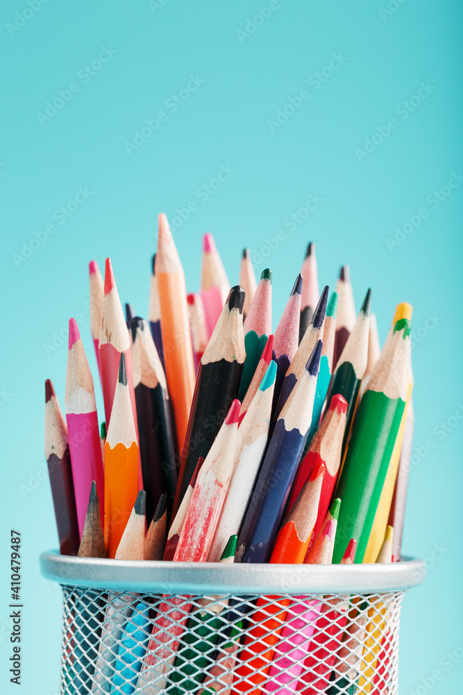 Pencils of different colors in a glass on a blue background. Pencils of different colors in a glass on a blue background.