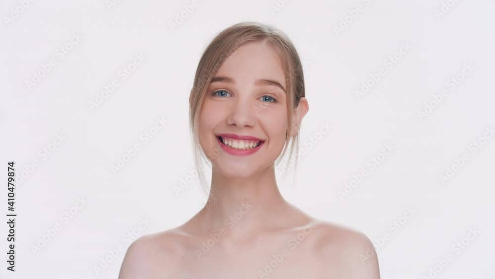 Young attractive blonde woman laughing at the camera against a light-grey background Young attractive blonde woman laughing at the camera against a light-grey background