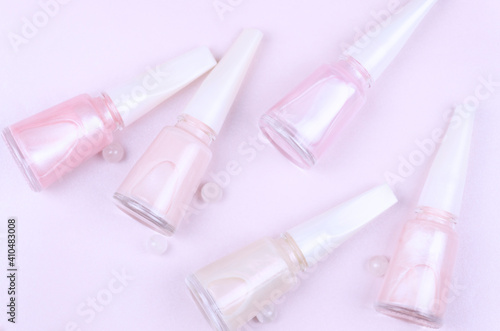 Bottles of pink pastel nail polish on a pink background.
