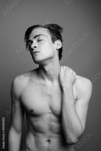 Young handsome man shirtless against gray background