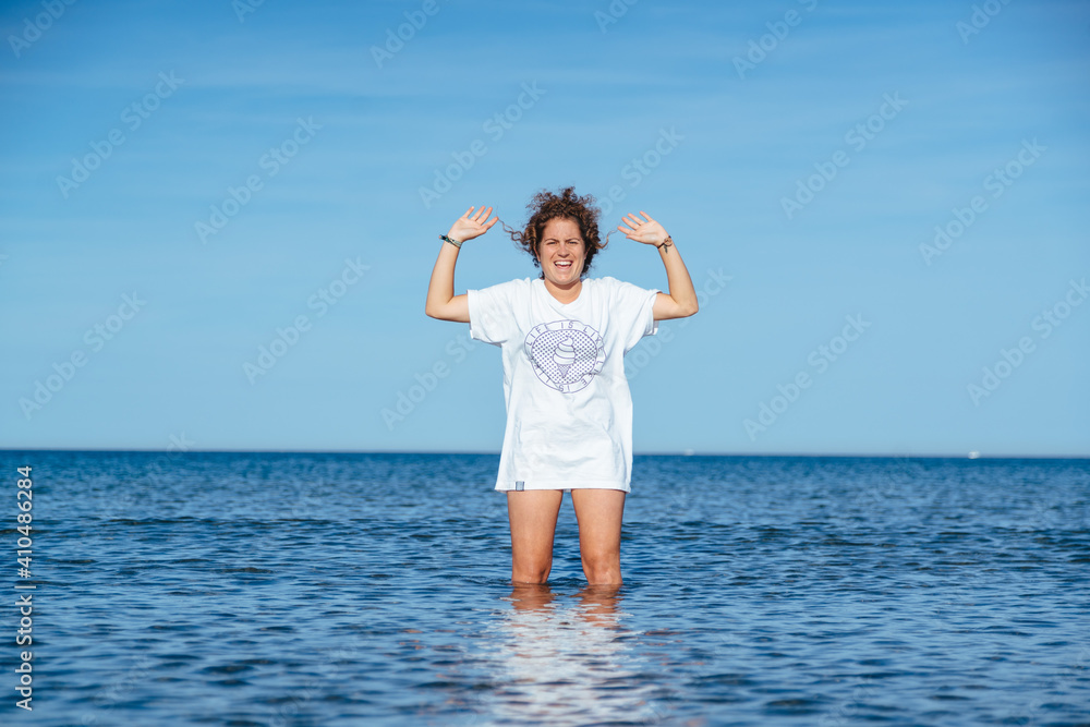Curly girl standing in ocean