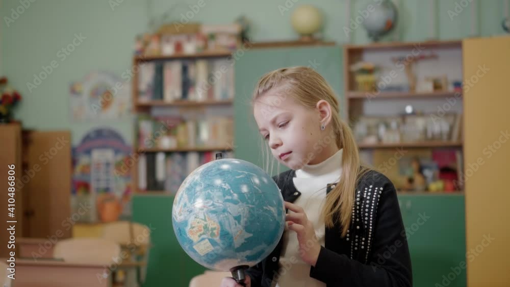 An elementary school student examines the globe. Study of the geography of the world. Education. An elementary school student examines the globe. Study of the geography of the world. Education.