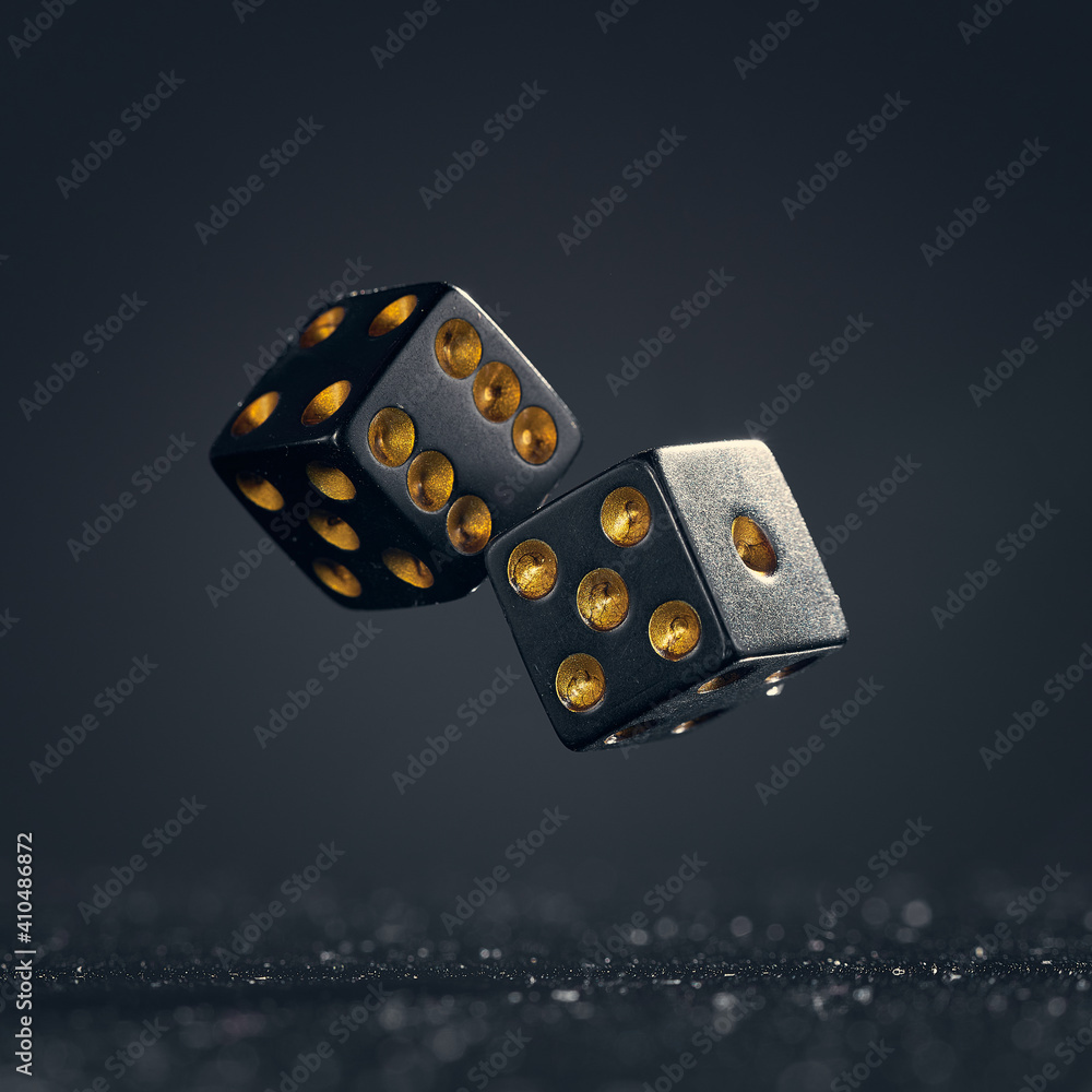 Two black dice are falling on a dark gray background. - obrazy, fototapety, plakaty 