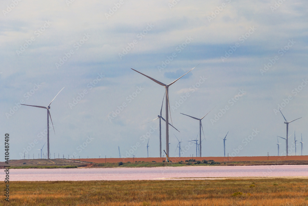 Wind turbines on a shore of the pink salty Syvash lake in Kherson region, Ukraine. Renewable energy Wind turbines on a shore of the pink salty Syvash lake in Kherson region, Ukraine. Renewable energy
