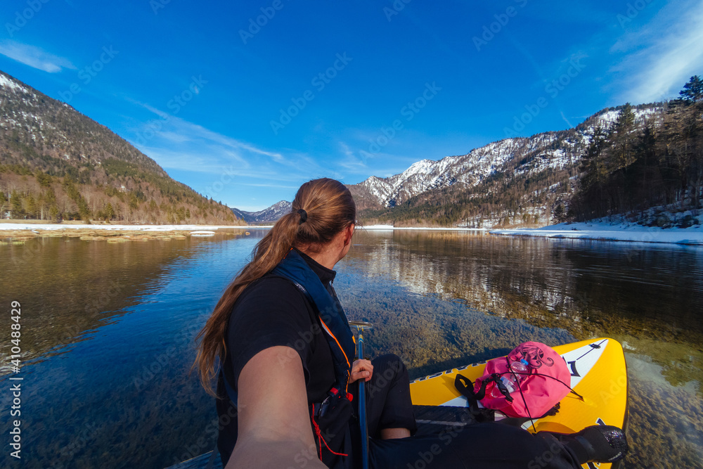 Stand up paddling through icy mountain lake