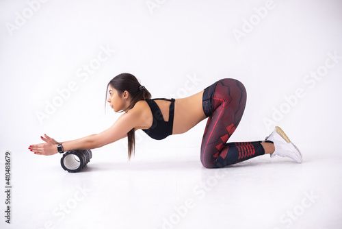 attractive caucasian woman exercising and flex with fitness foam roller exercises on white background